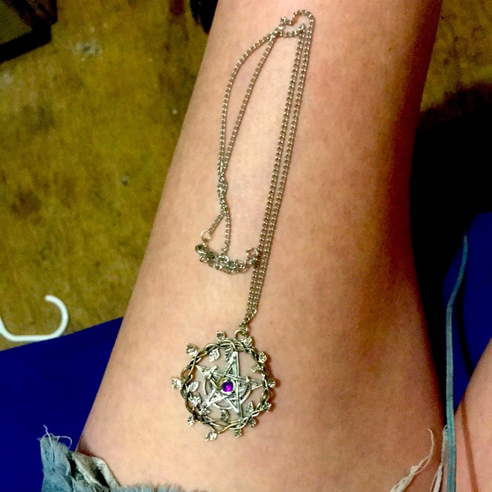 Star necklace with purple jewel and  leaf circle around it